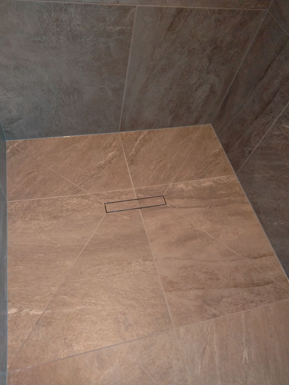 Detaljebillede af fliser lagt i brusekabine på nyt badeværelse i Thsited